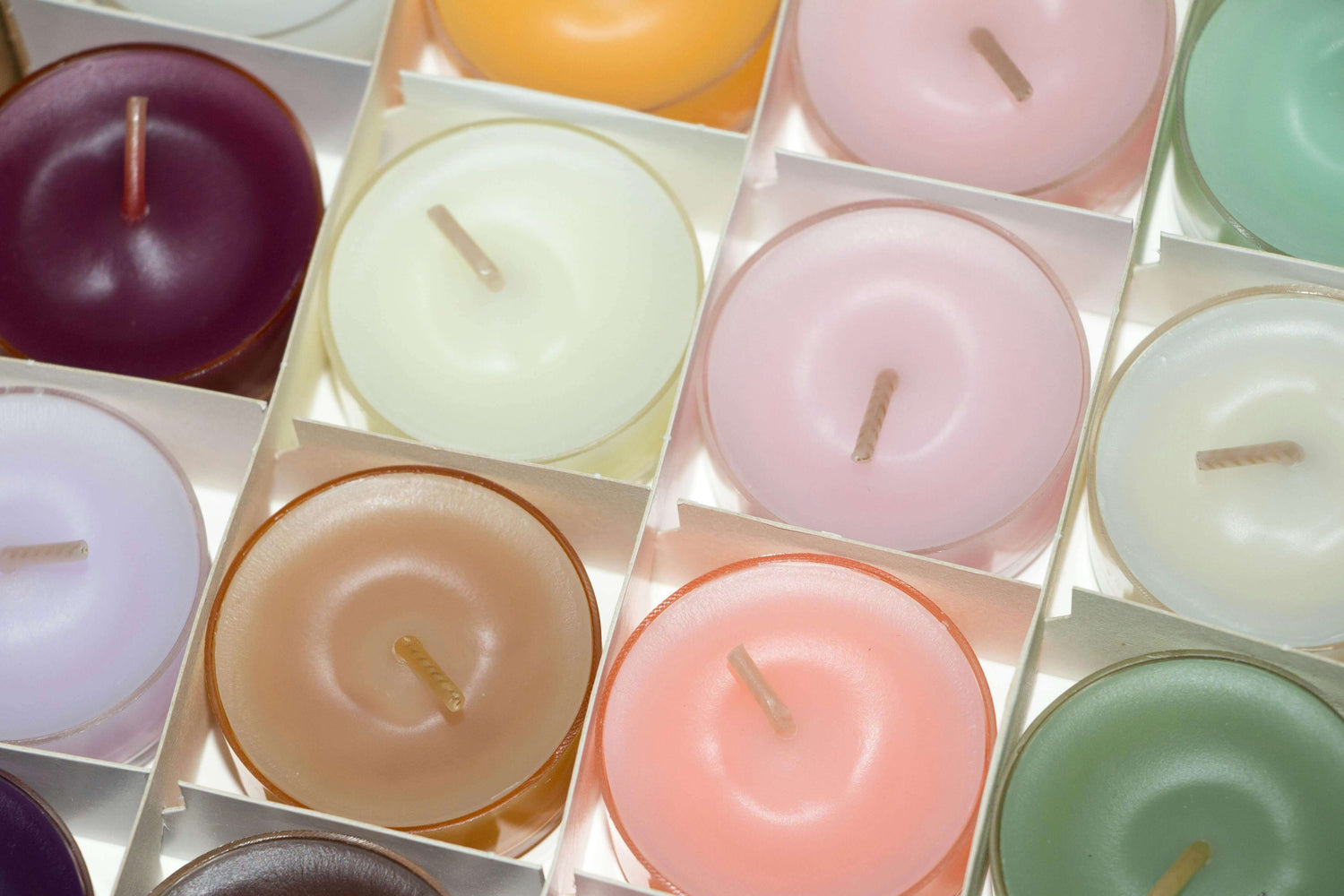 Colorful scented candles from the Bougies & Parfums d'ambiance collection, displayed in a neat grid.