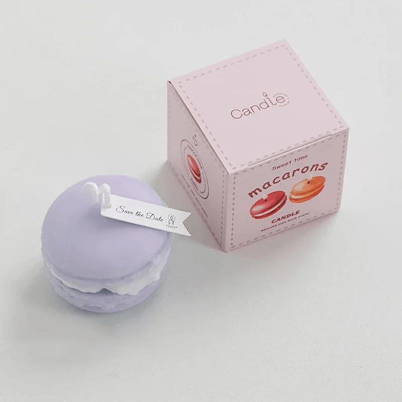 Bougie macaron parfumée violette avec boîte rose, idéale pour une ambiance élégante et gourmande