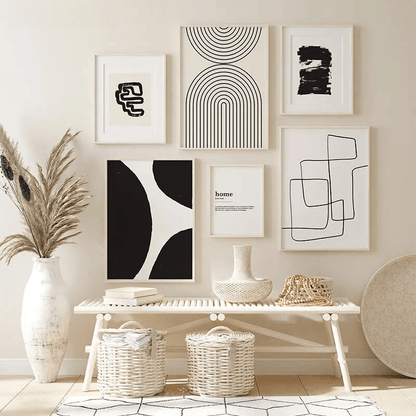 Mur de cadres artistiques abstraits noir et blanc dans un intérieur moderne avec des paniers en osier et un banc en bois.