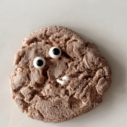 Bougie parfumée en forme de cookie réaliste avec des yeux googly fabriquée en cire de soja naturelle.