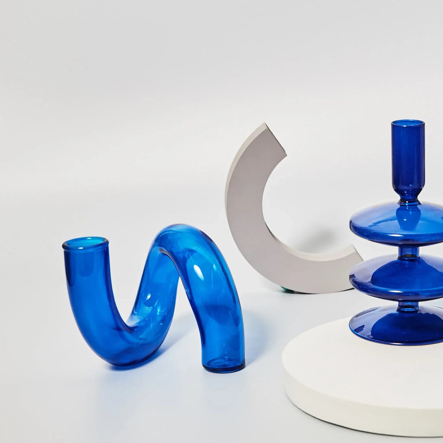 Blue borosilicate glass vases with modern shapes displayed on a white background