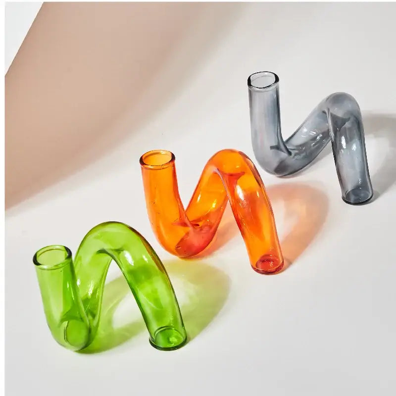 Vintage colored glass vases in green, orange, and gray, perfect for elegant home decor and candle display