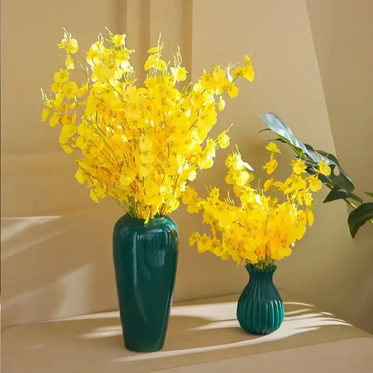 Bouquet de fleurs d'Orchidée jaune dans deux vases verts, ajoutant une touche d'élégance et de sophistication à un intérieur lumineux.