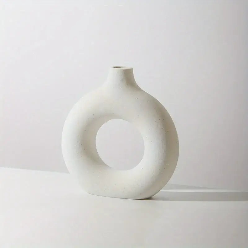 White ceramic donut-shaped vase with minimalist design perfect for dry flowers or bouquets, enhancing modern interior decor.