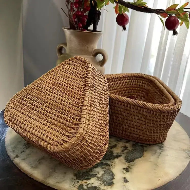 Panier de rangement en osier tressé, design artisanal élégant, fabriqué à partir de matériaux naturels, sur une table en marbre.