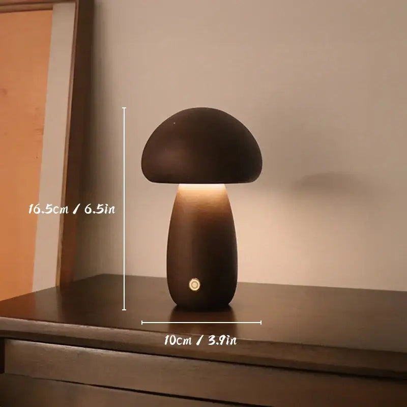 Lampe de table champignon en bois sur une table, mesurant 16,5 cm de hauteur et 10 cm de largeur, émettant une lumière douce.