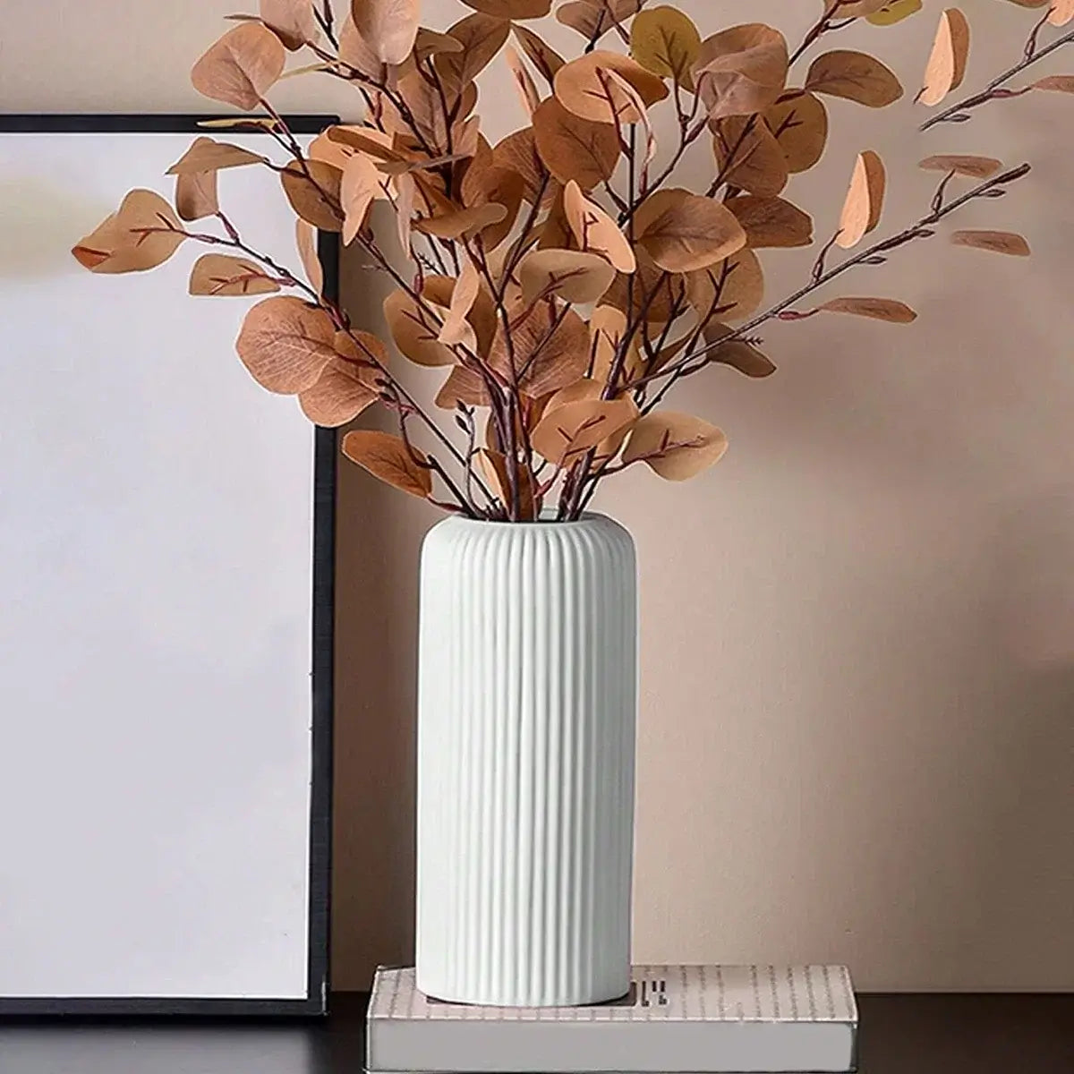 Vase en plastique effet céramique strié avec feuilles décoratives séchées, idéal pour décoration intérieure élégante.