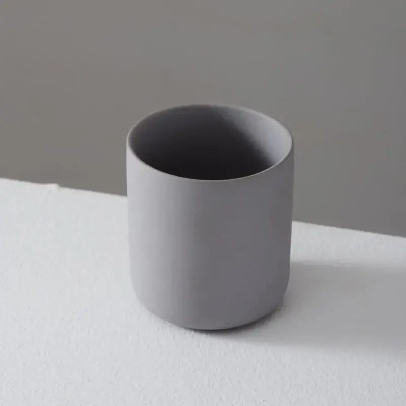 Bougeoir en céramique gris avec surface mate sur fond gris et blanc