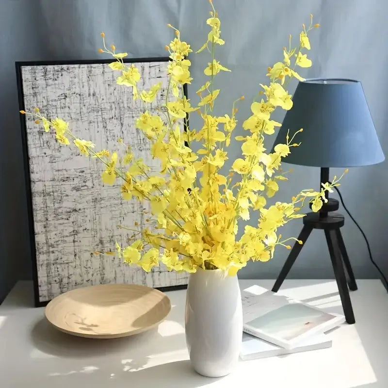 Yellow Orchid Flower Bouquet in White Vase on Desk near Lamp and Artwork