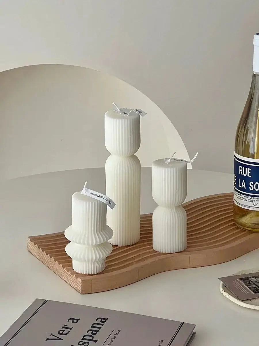 Bougie géométrique parfumée sur plateau en bois, ajoutant une touche d'élégance moderne à la décoration intérieure.