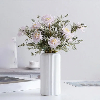 Striped ceramic-look plastic vase with pink flowers, adding elegance to home decor. Ideal for stylish floral arrangements.