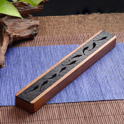 Sculpted Asian wooden incense box made of ebony and boxwood on a bamboo mat, perfect for a zen and elegant home decor.