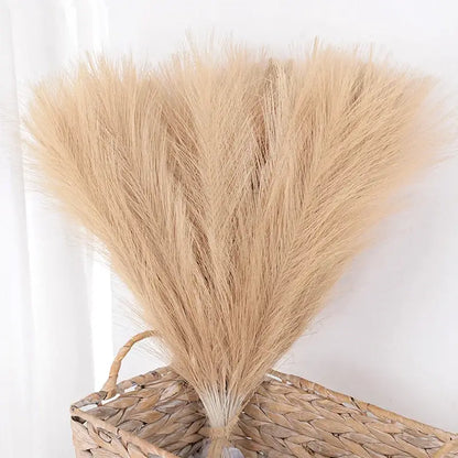 Bouquet de tiges de pampas naturelles dans un panier tressé, décoration élégante pour intérieur ou événements festifs.