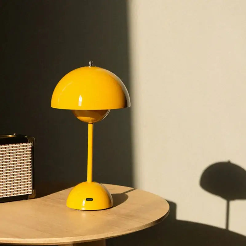 Lampe de Table LED design champignon jaune sur une table en bois, offrant un éclairage moderne et élégant pour une ambiance douce et colorée.