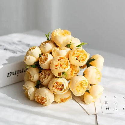 Bouquet de fleurs de pivoines en soie rose avec 27 têtes de roses sur une table blanche, ajoutant une touche d'élégance à la décoration.