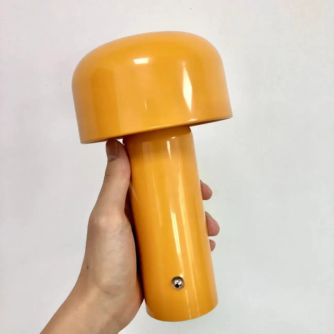 Person holding a yellow LED mini mushroom table lamp for modern and stylish lighting.