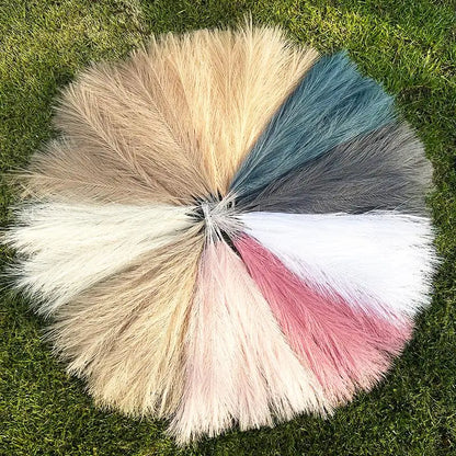 Bouquet de tiges de pampas multicolores disposé en cercle sur une pelouse verte, parfait pour décoration d'événements et espaces intérieurs.