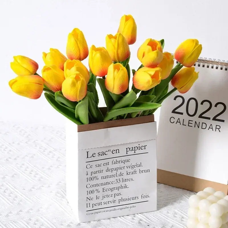 Bouquet de tulipes en soie jaunes dans un vase en papier avec un calendrier 2022 en arrière-plan, idéal pour la décoration intérieure