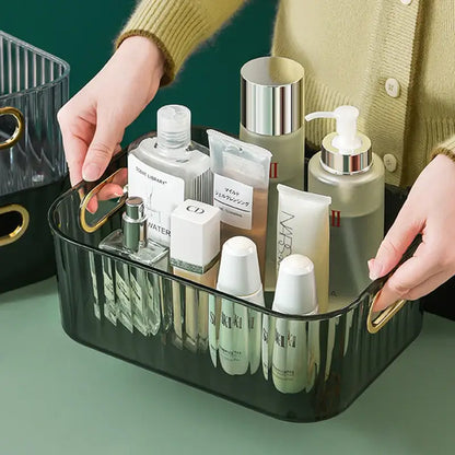 Person holding a transparent, textured storage box filled with various cosmetics and skincare products.