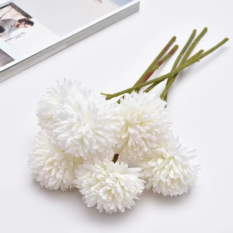 Silk chrysanthemum bouquet with five white flower heads on a white surface, perfect for elegant home decoration or special occasions.