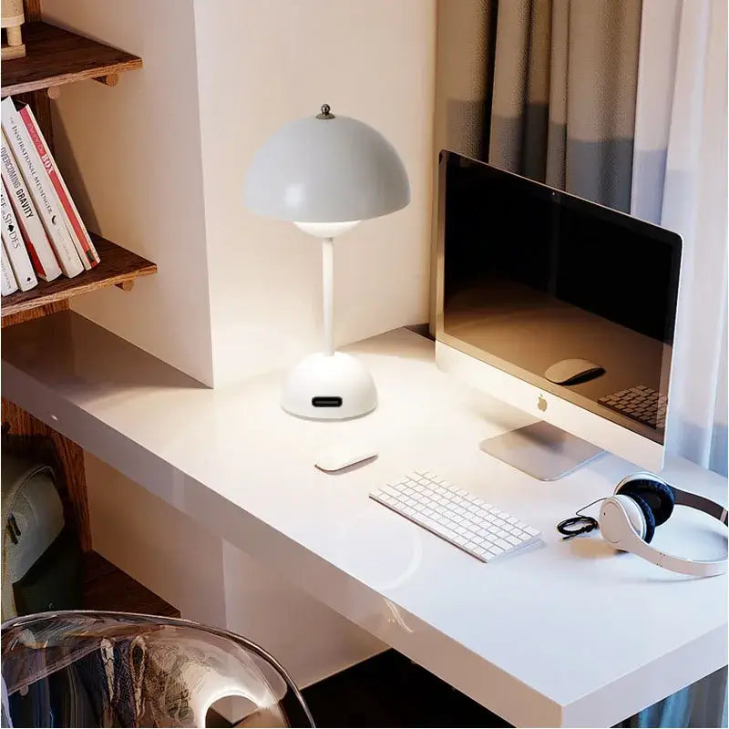 Lampe de table LED design champignon sur bureau moderne, éclairage ajustable pour une ambiance élégante dans un espace de travail.