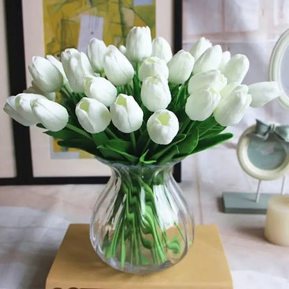 Magnifique bouquet de tulipes en soie blanches dans un vase en verre, ajoutant une touche d'élégance à un intérieur moderne.