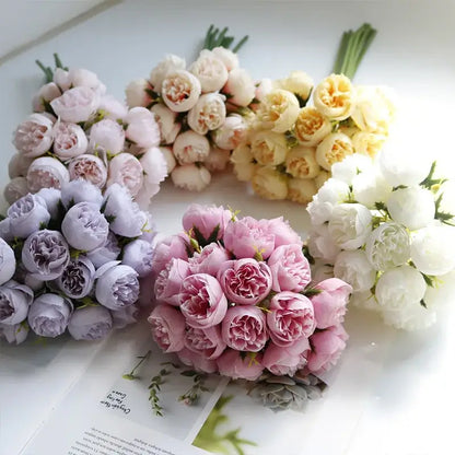 Bouquets de pivoines en soie de différentes couleurs disposés sur une table, ajoutant une touche élégante et intemporelle à la décoration intérieure.