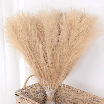 Bouquet de tiges de pampas beige dans un panier en osier pour décoration élégante et naturelle.