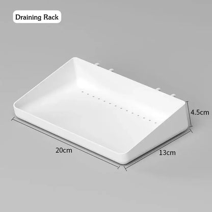 White plastic draining rack with dimensions 20cm x 13cm x 4.5cm, designed for wall-mounted kitchen organization.