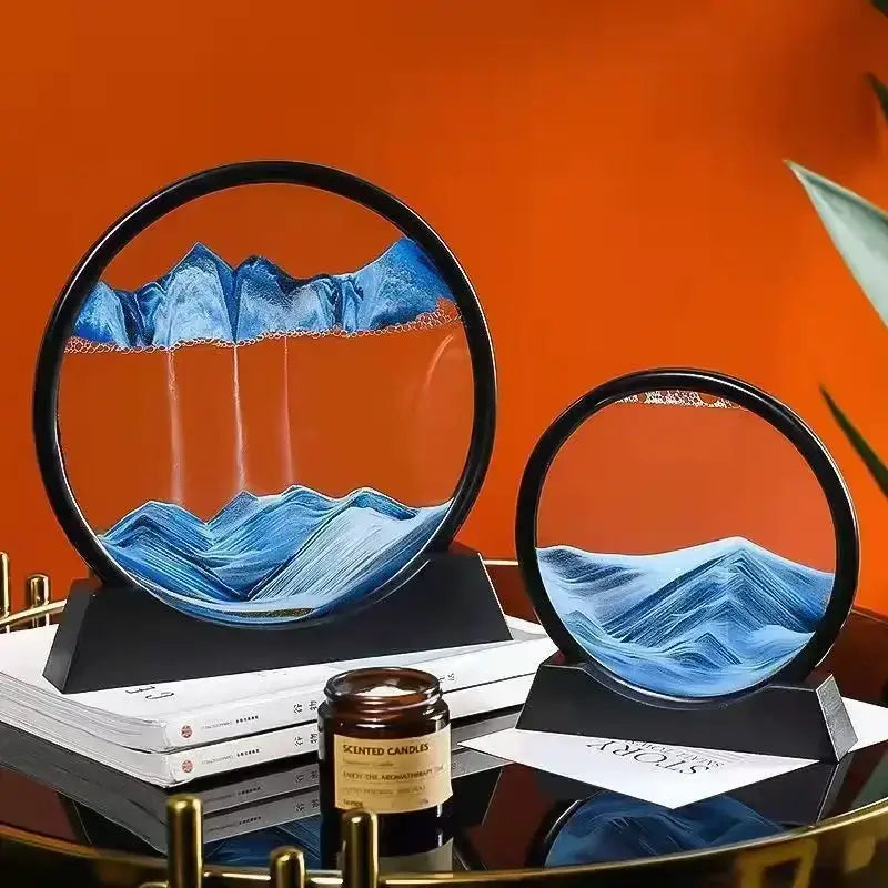 Sablier décoratif circulaire en verre avec paysages bleus, posé sur une table avec une bougie parfumée.