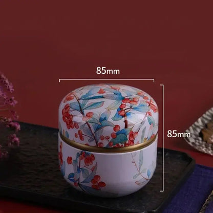 Boîte de rangement en métal décoré avec motif floral, dimensions 85mm x 85mm, idéal pour organiser petits objets.