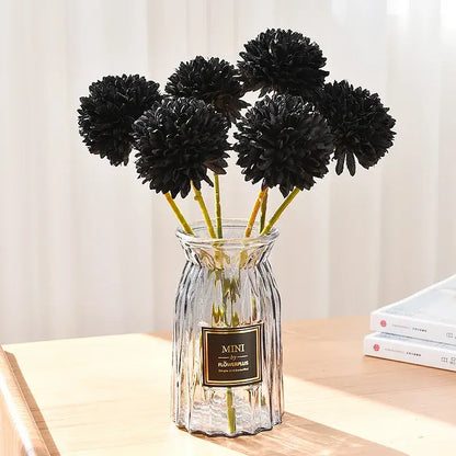 Bouquet de chrysanthèmes noirs en soie dans un vase en verre sur une table, décoration intérieure élégante et moderne