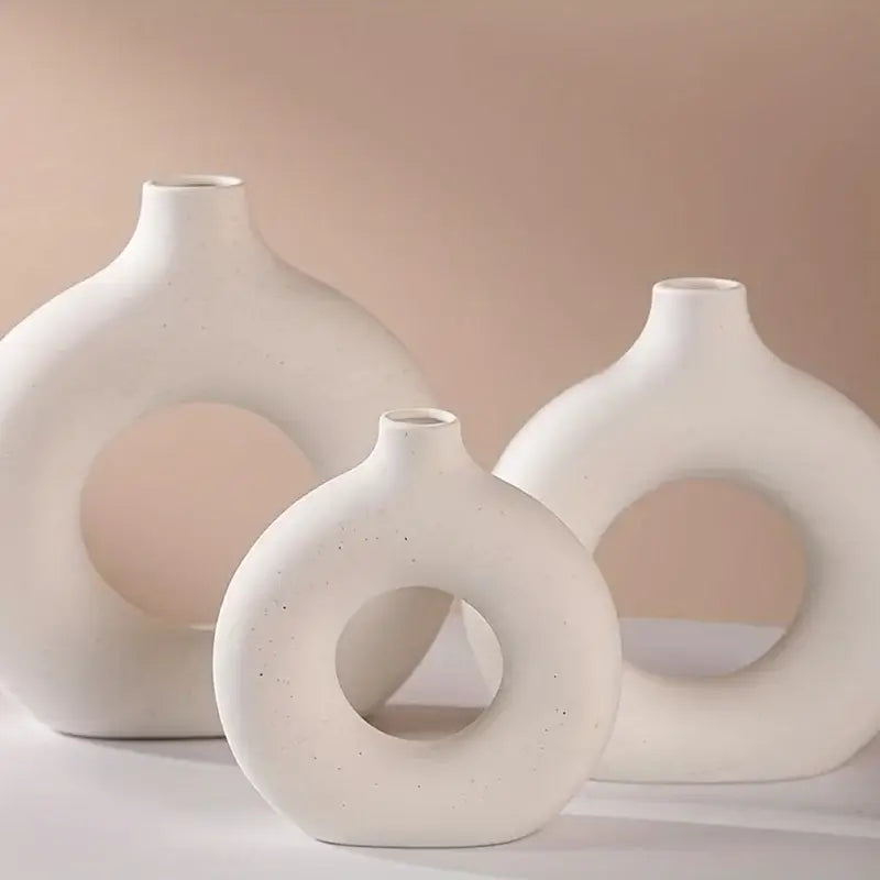 Three white ceramic donut vases with minimalist design, perfect for enhancing home decor with elegance and modern style.