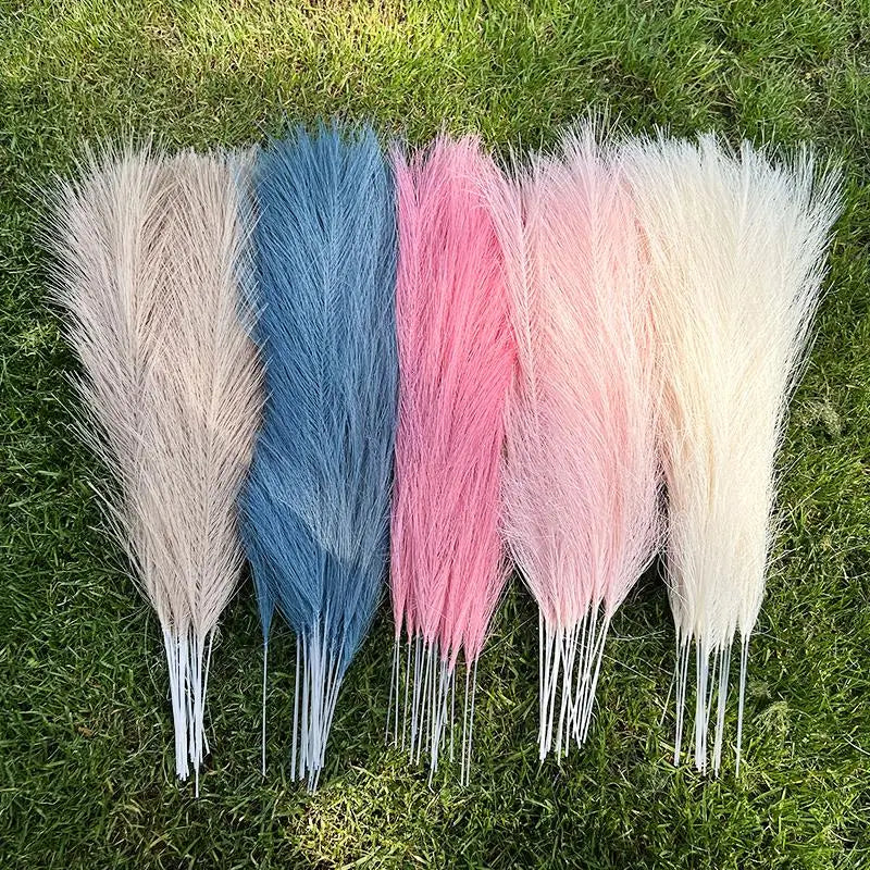 Multicolored artificial pampas grass bouquet displayed on grass, featuring shades of beige, blue, pink, and white.