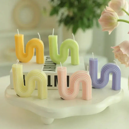 Colorful S-shaped scented candles on white tray, creating a nordic, elegant ambiance for home décor.