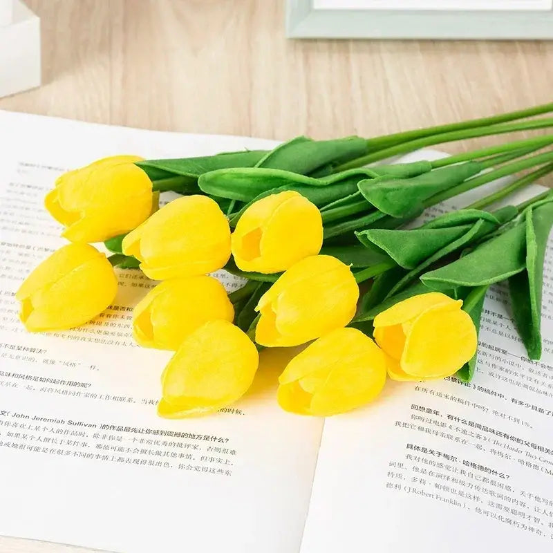 Yellow silk tulip bouquet on top of open books, perfect for adding elegance to home décor, weddings, and special occasions.