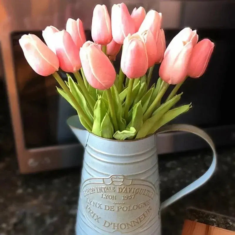 Bouquet de tulipes en soie roses dans un pot décoratif, ajoutant une touche d'élégance à la décoration intérieure.