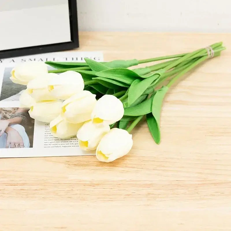 Bouquet de tulipes en soie blanche sur une table en bois, idéal pour la décoration intérieure et les occasions spéciales