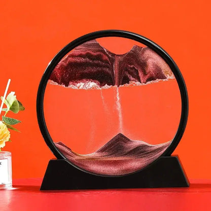 Sablier décoratif circulaire en verre noir avec sable rouge sur fond orange vibrant