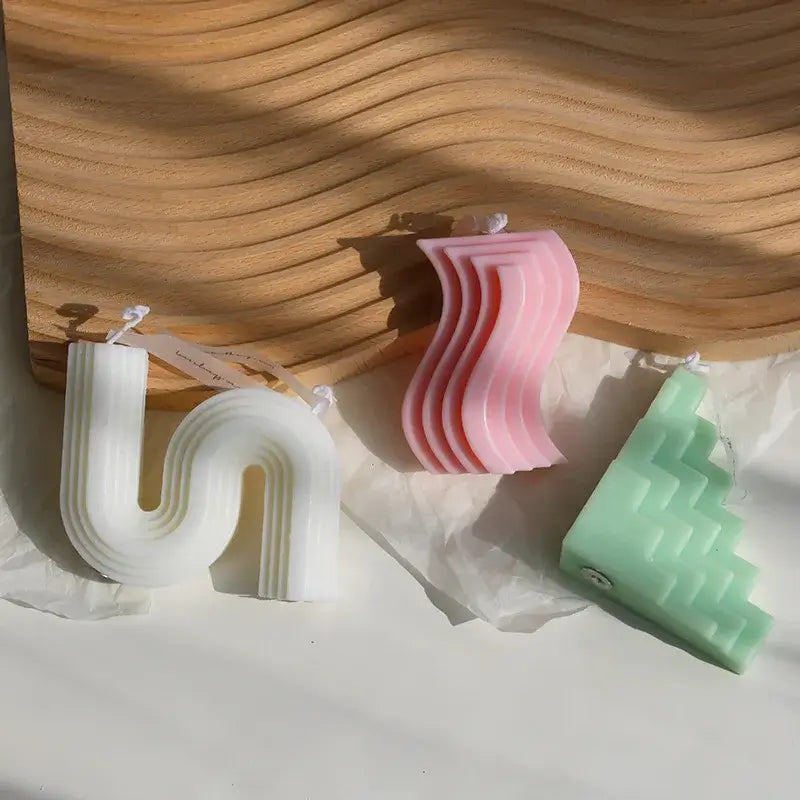 Bougie d'aromathérapie zigzag en cire de soja naturelle avec design sculptural wavy en blanc, rose et vert pastels.