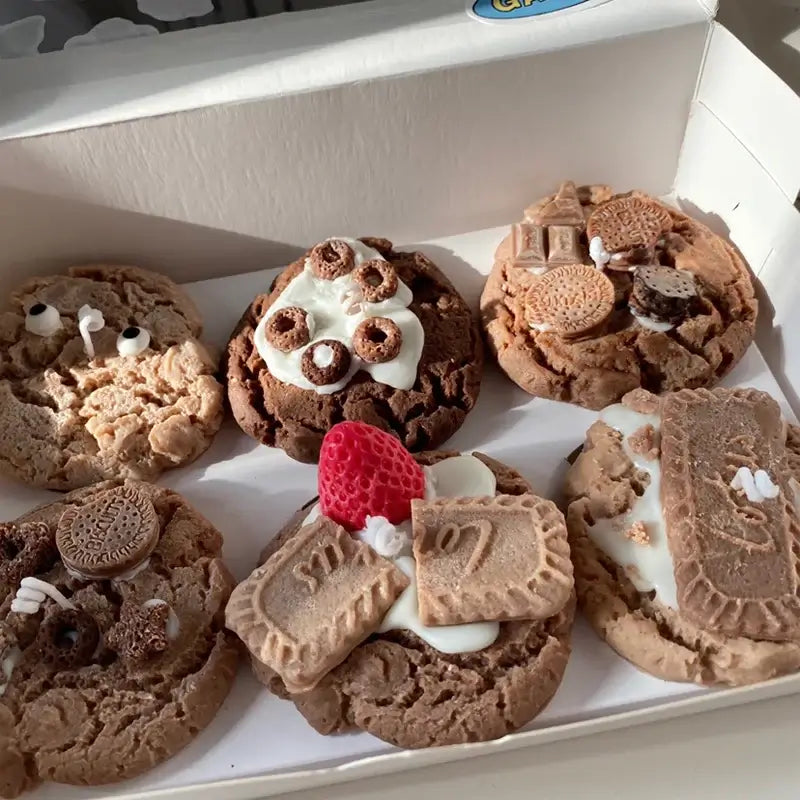 Bougies parfumées en forme de cookies en cire de soja, affichées dans une boîte, imitant des biscuits appétissants avec des décorations réalistes.