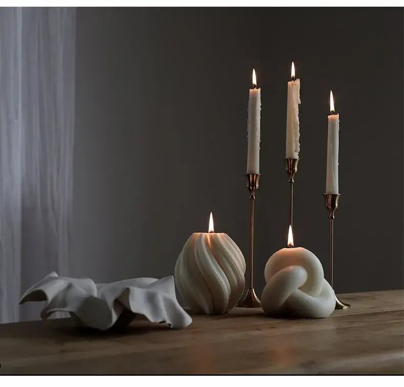 Bougie parfumée design Tourbillon sur une table en bois avec bougies décoratives et chandeliers élégants, idéale pour une ambiance cosy.