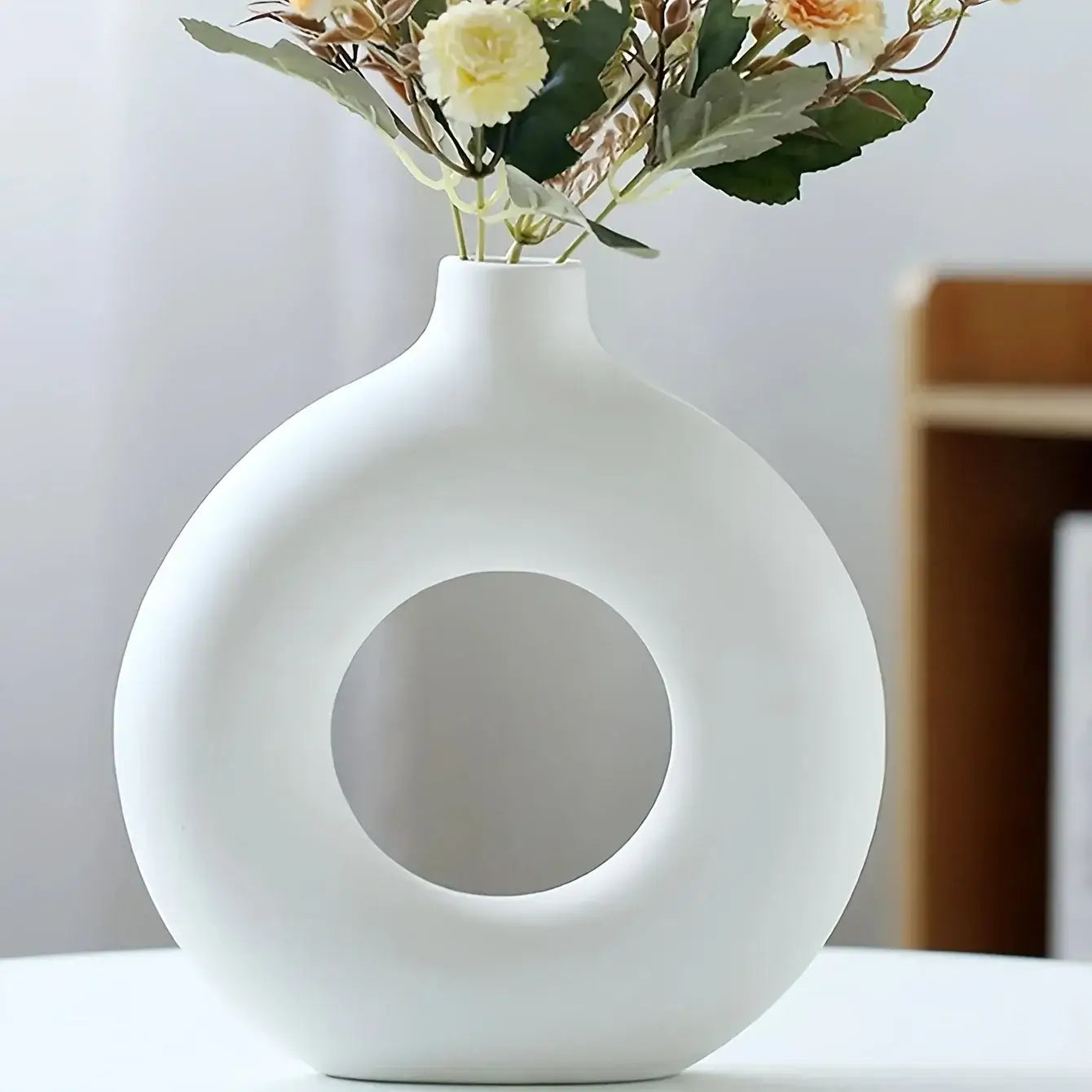 Vase donut en céramique blanc avec des fleurs séchées, design minimaliste et élégant pour la décoration intérieure moderne