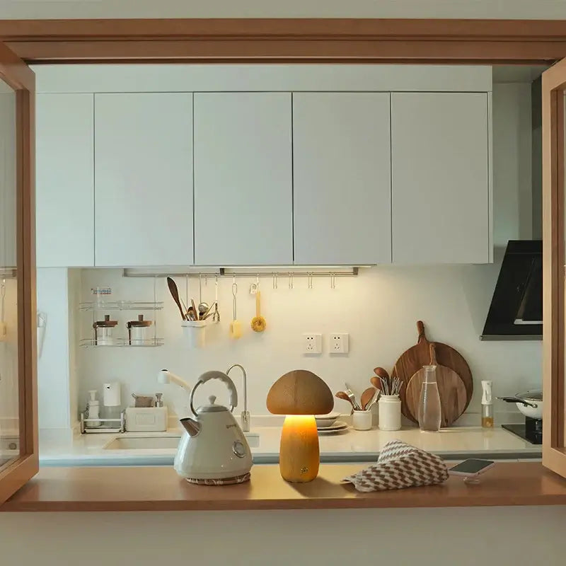 Lampe de table champignon en bois allumée dans une cuisine élégante et moderne.