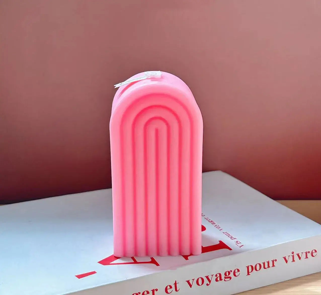 Bougie d'aromathérapie arche en cire de soja rose sur un livre, design sculptural unique pour une ambiance relaxante