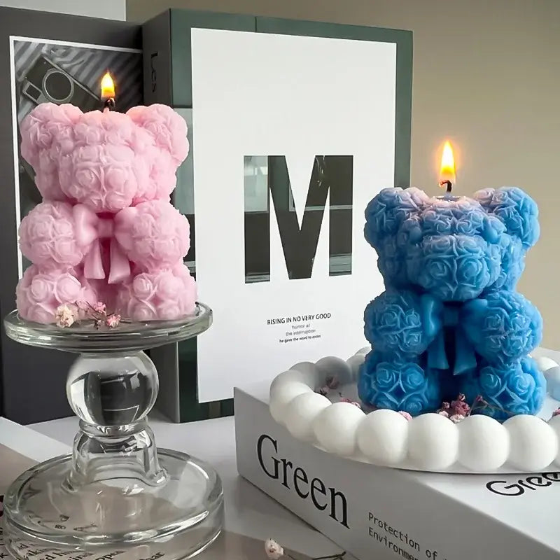 Bougie aromathérapie en forme d'ours en peluche rose et bleue, faite à la main en cire de soja respectueuse de l'environnement, sur un présentoir.