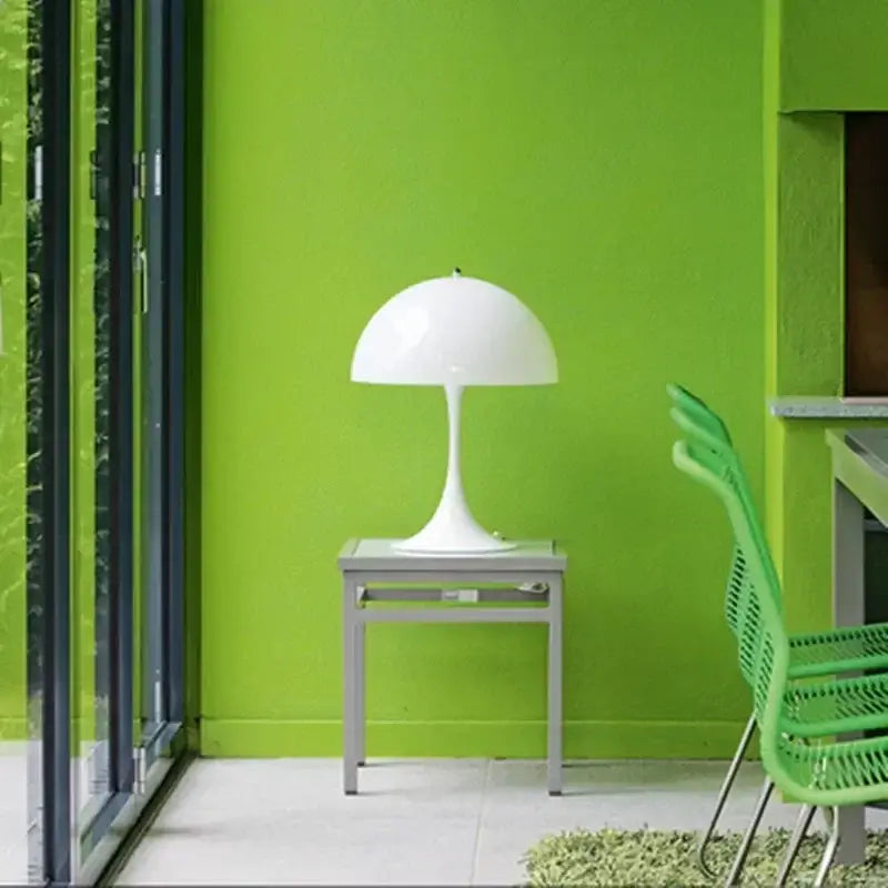 Minimalist LED mushroom lamp on table against green wall in modern room