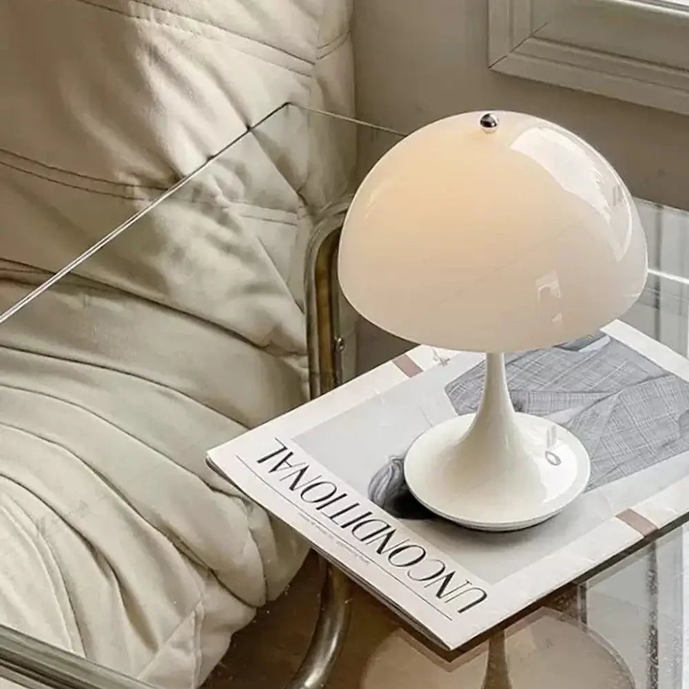 Lampe de table LED fleur blanche sur une table en verre, apportant une élégance minimaliste et un éclairage doux à une chambre moderne