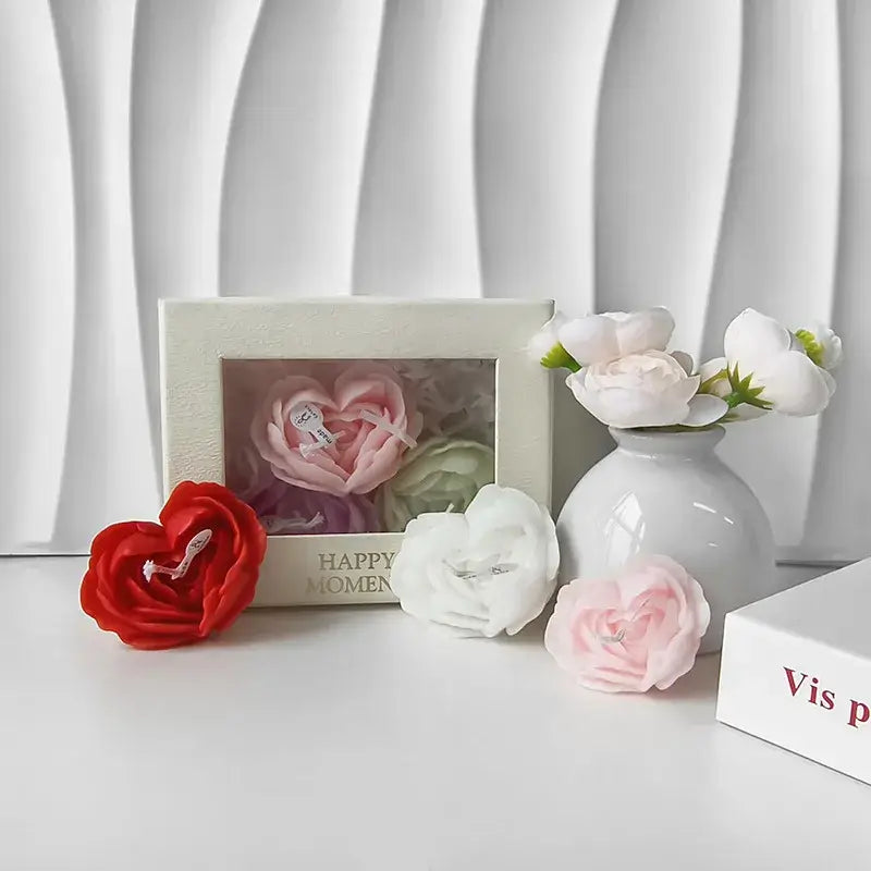 Bougies parfumées en forme de rose, et vase avec fleurs blanches, créant une ambiance romantique et apaisante sur une table blanche