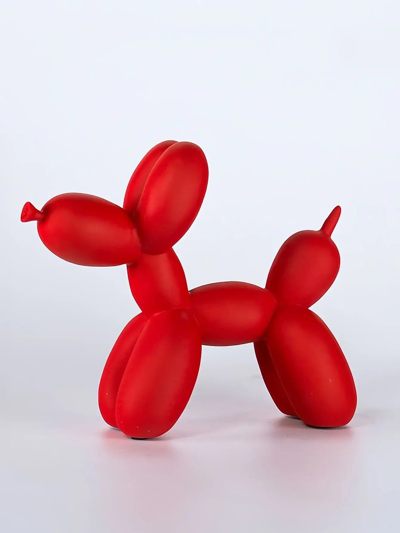 Statuette de chien en ballon rouge en résine haute qualité, ajoutant une touche ludique et originale à la décoration intérieure.